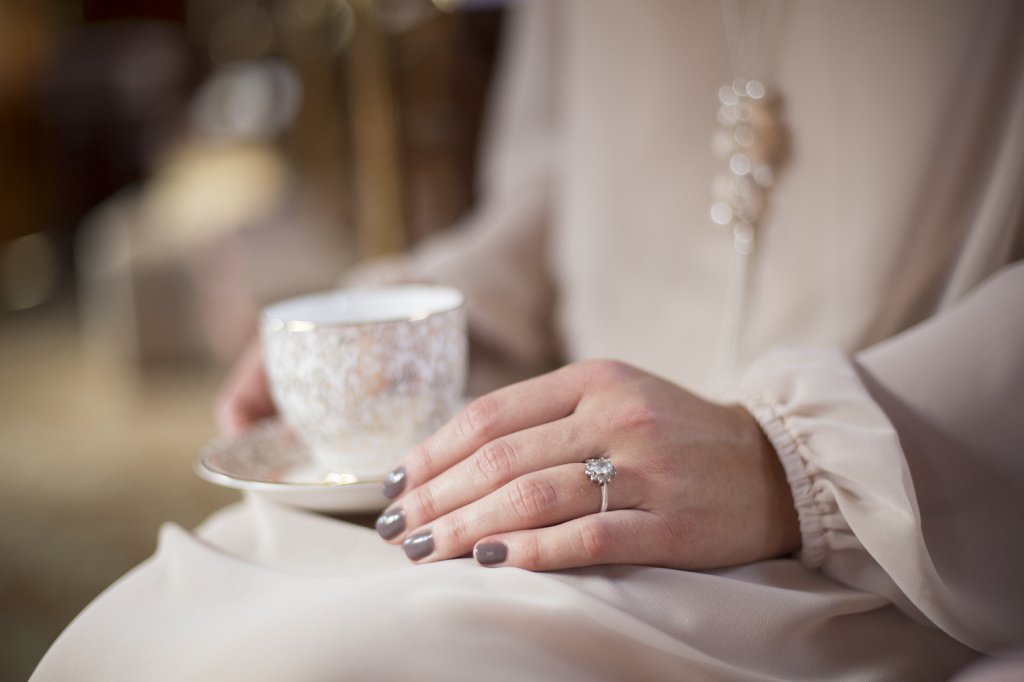 Photo Bride holding a golden vintage cup in lap