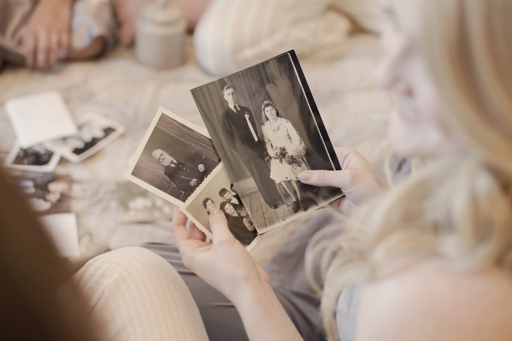 Photo Girl holding vintage photographs of her parents in hands