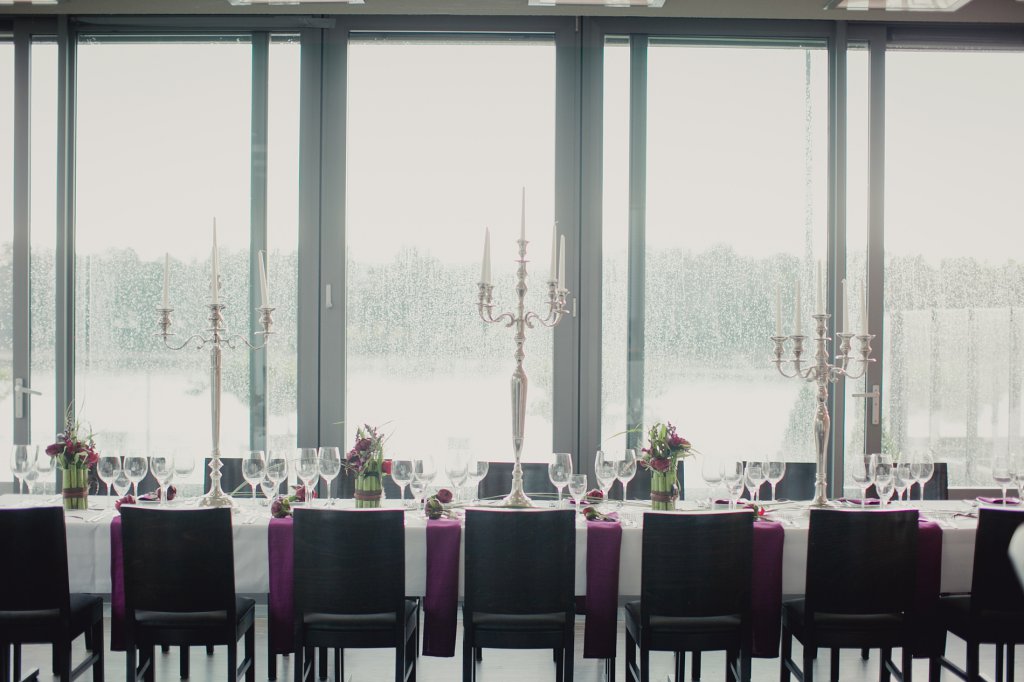 Photo Festtafel mit dunklen Stühlen und hohen silbernen Kerzenleuchtern.